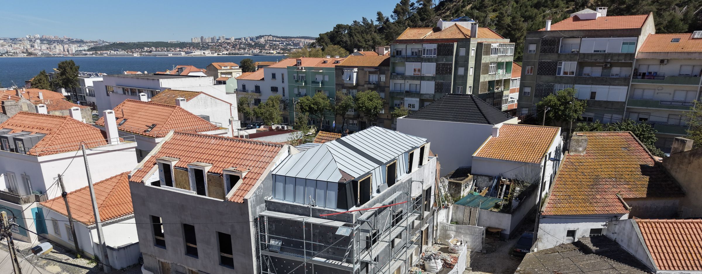 Prédio em construção na Trafaria, com o Tejo e Lisboa ao fundo